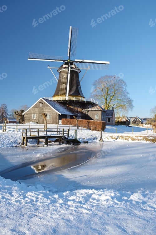 Preview: old historical wooden windmill in the snow in the Netherlands during winter