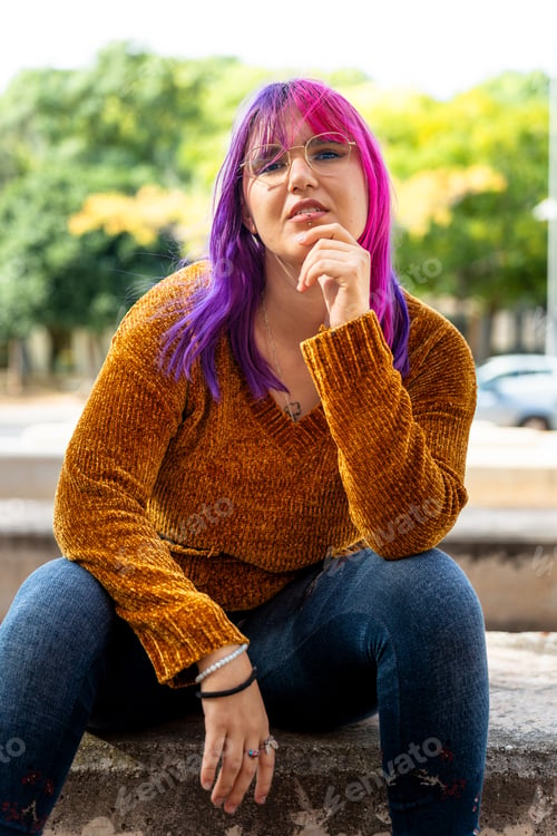 Preview: Body positive autistic girl with pink hair looking at camera interested