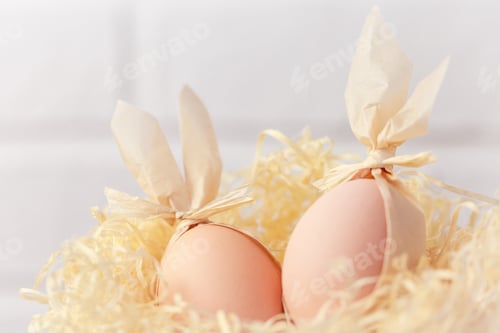 Preview: Easter creative. Two eggs with rabbit ears in a nest, decoration idea