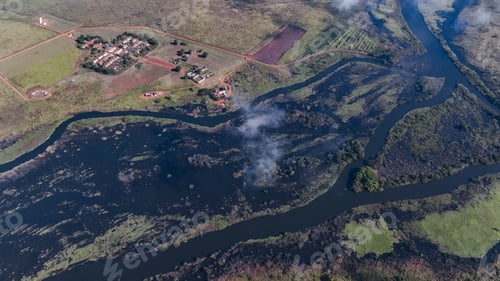 Preview: Aerial view of Angola\'s farmlands featuring rivers and lush landscape under clear skies