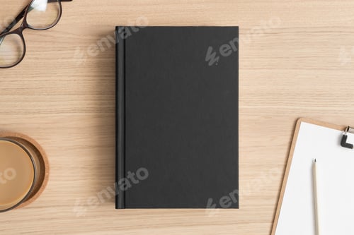 Preview: Black book mockup with workspace accessories on the wooden table.