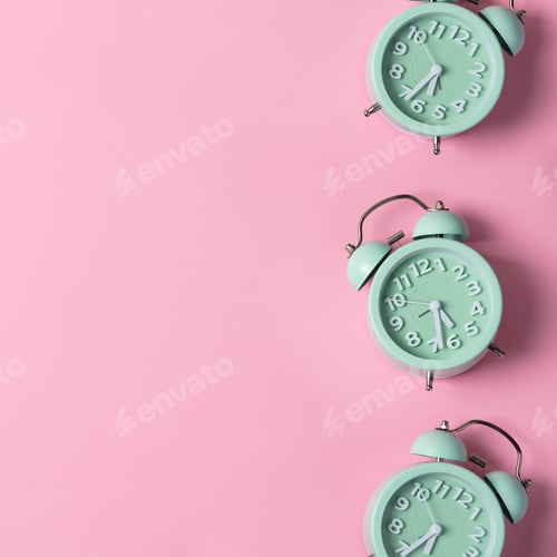 Preview: Creative layout of green alarm clock's on pastel pink background. Minimal concept.
