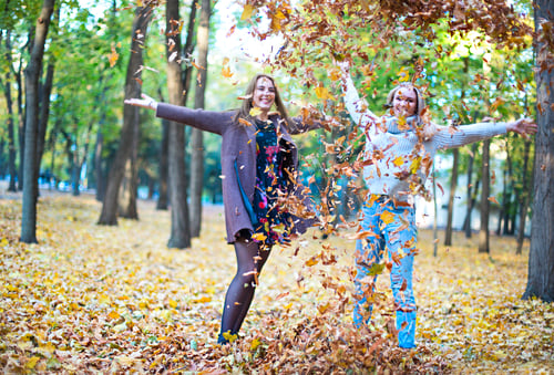 Preview: Fashionable beautiful young girlfriends walking together in the autumn park background
