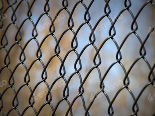 Preview: Chain Link Fence With Blurred Trees And Sky Background - Photograph Of A Chain Link Fence With A