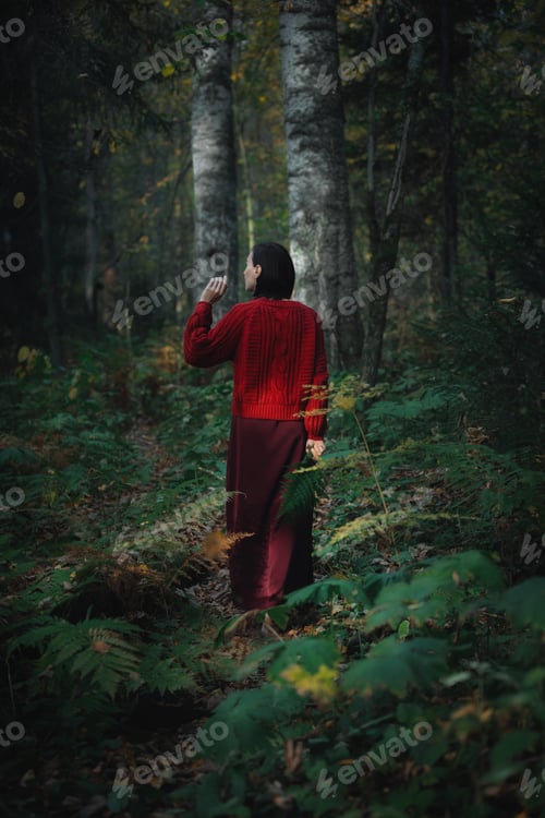 Preview: Walking in a forest while wearing a red sweater and red pants during autumn season