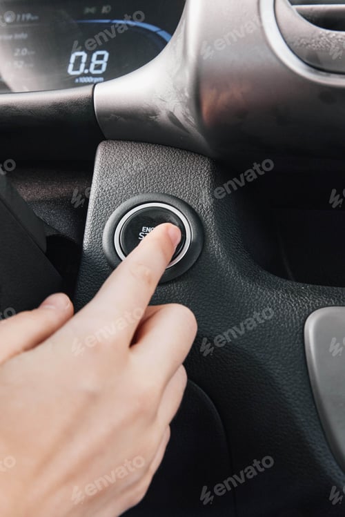Preview: Driver pressing a button on the steering wheel of a modern car; closeup view of hands interacting