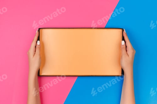 Preview: Female hands with open empty box on blue and pink background