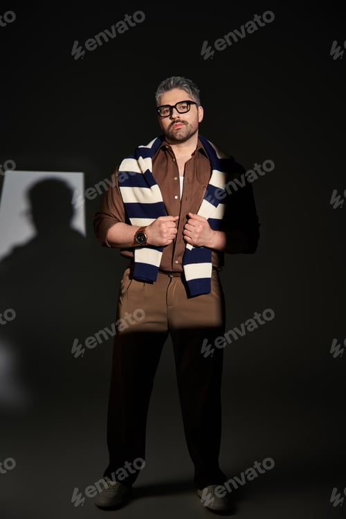 Preview: Stylish man in glasses showcases elegance and fashion in studio environment