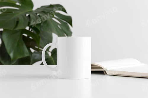 Preview: Mug mockup with workspace accessories and a monstera plant.