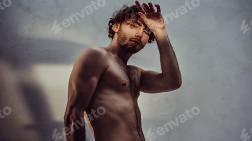 Preview: Young caucasian male model is naked and isolated on the grey background