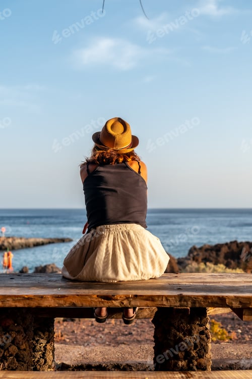 Preview: Portrait of a female tourist at sunset looking at the sea Tacoron beach on El Hierro, Canary Islands