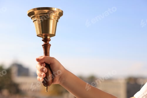 Preview: Pupil with school bell outdoors, closeup. Space for text