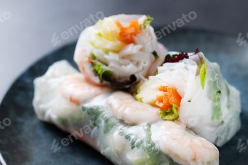 Preview: Vietnamese spring rolls with vegetables, rice noodles and prawns on black slate background