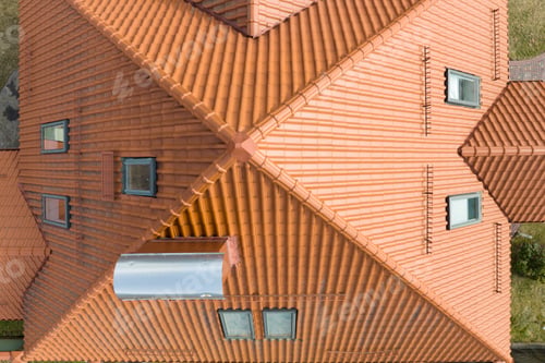 Preview: Closeup of attic windows on house roof top covered with ceramic shingles. Tiled covering of building