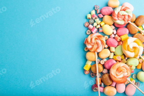 Preview: Various caramel candies on blue background. copy space, top view
