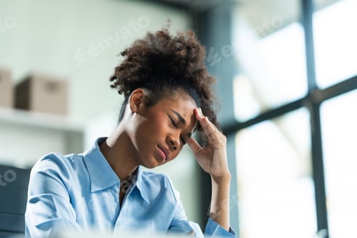 Preview: A young African American woman with Afro brown hair in a modern office experiencing panic