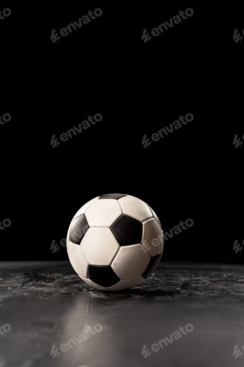 Preview: Single soccer ball on black floor