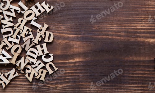 Preview: Letters of the English alphabet on a dark wooden background.