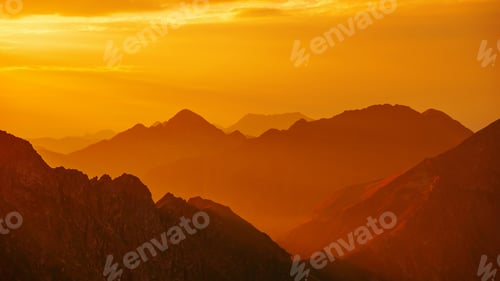 Preview: Silhouetted orange mountains and horizon at Fagaras mountains, Moldoveanu peak,