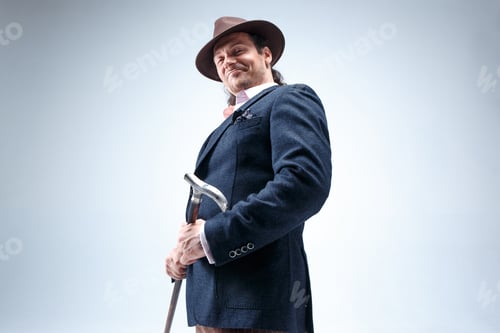 Preview: The Mature Man In A Suit And Hat Holding Cane.