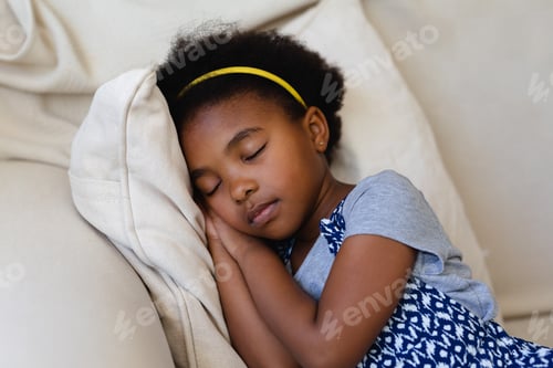 Preview: Cute african american girl sleeping on the couch at home
