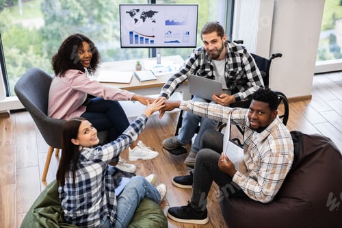 Preview: Diverse team collaborating with hands together during business meeting