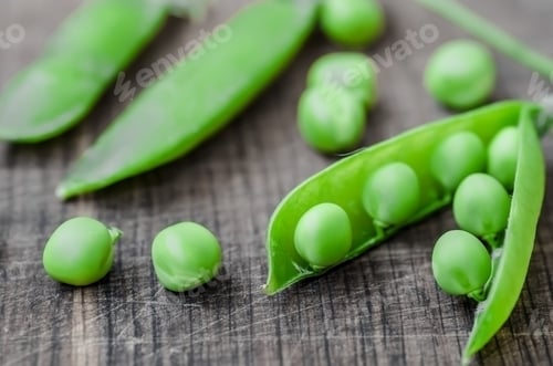 Preview: Green organic peas on wooden background, shalow focus