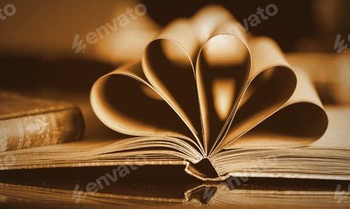Preview: Old notebook with unfolded and folded pages in the shape of a heart on a desk.