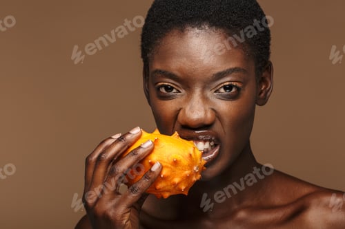 Preview: Beauty portrait of half-naked african woman holding kiwano horned melon