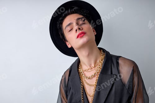 Preview: Male makeup look. Portrait of pacified guy with make-up, in hat and chain, cool and modern