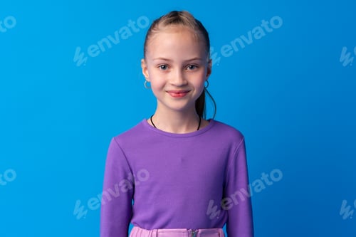Preview: Portrait of a little smiling girl preteen on blue background