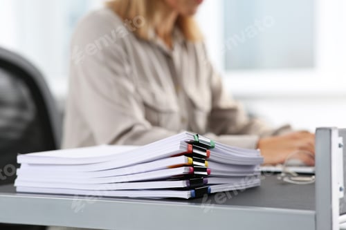Preview: Businesswoman working with laptop at table in office, focus on documents