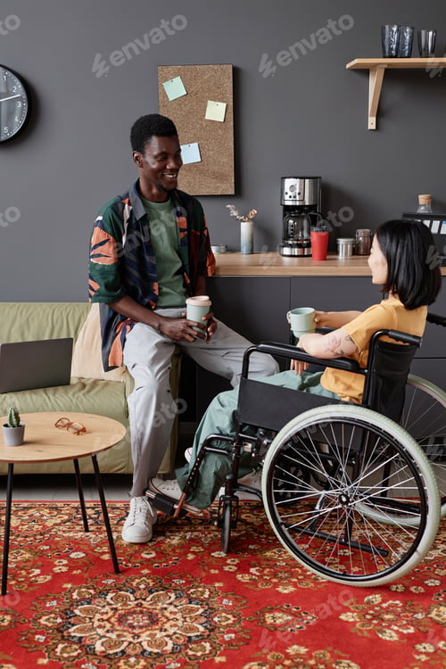 Preview: Young woman with disability enjoying talk with colleague during coffee break