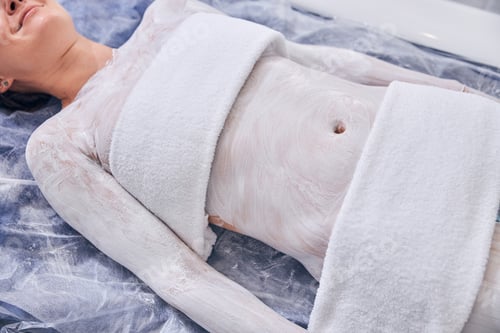 Preview: Body of young female with two towels on it in spa treatment