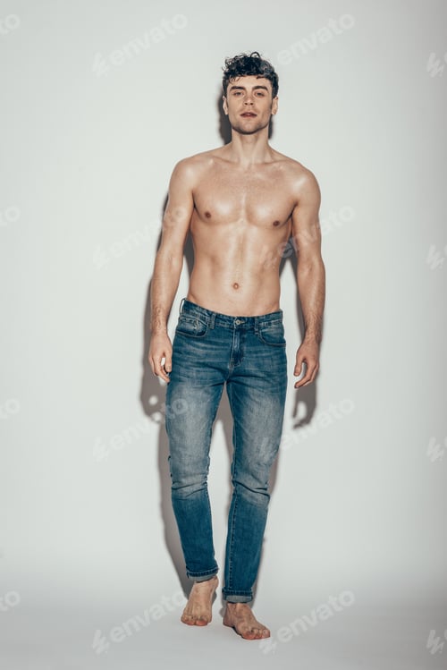 Preview: sexy shirtless macho in jeans posing on grey