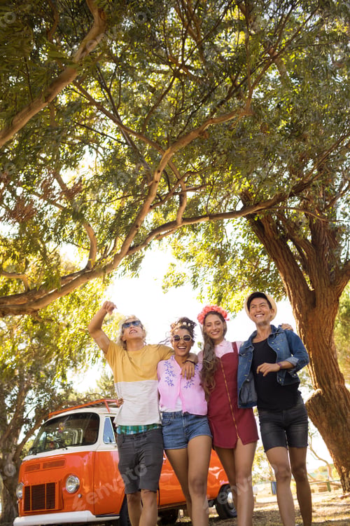 Preview: Smiling friends walking on field