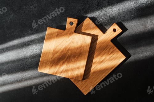 Preview: Modern wooden cutting boards on a dark countertop with sunlight shadows