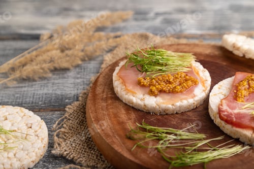Preview: Puffed rice cake sandwiches with jerky salted meat, carrot microgreen on gray wooden