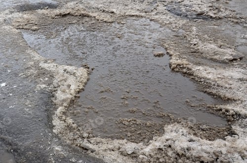 Preview: Damaged asphalt road with potholes caused by freezing and thawing cycles