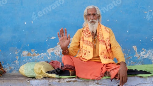 Preview: Religious ascetic Sadhu in traditional Indian clothes sitting outdoor