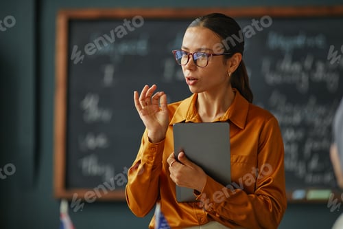 Preview: Caucasian Young Adult Woman Explaining Lesson While Holding Digital Tablet