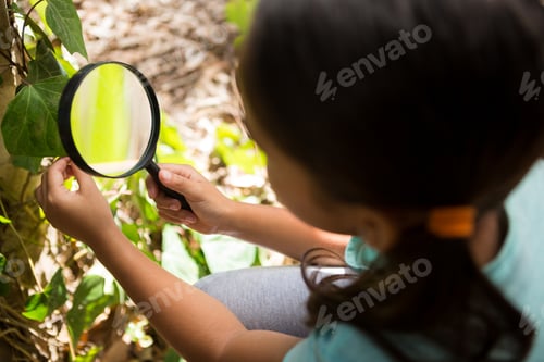 Preview: Little girl exploring nature through magnifying glass