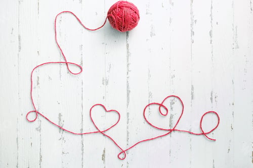 Preview: Red thread, two hearts and tangle on light wooden background