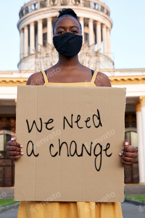 Preview: Young african woman wear black face mask stand outdoors holding sign protesting.