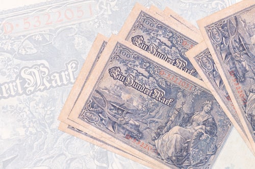 Preview: 100 Reich marks bills lies in stack on background of big semi-transparent banknote. Abstract presen