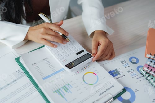 Preview: Businesswoman analyzing financial reports and using calculator for accounting