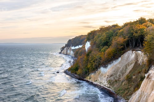 Preview: Autumn chalk cliffs over the sea at soft sunset. Baltic coast, golden forest.