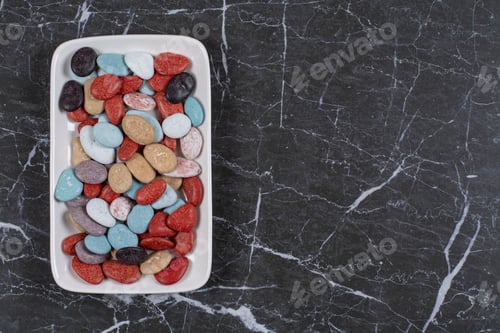 Preview: A stack of candies in the plate, on the marble background