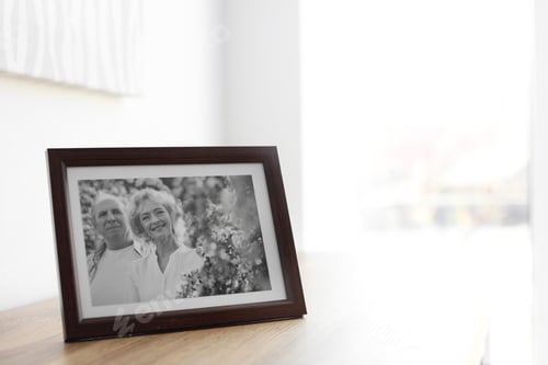 Preview: Portrait of senior couple in frame on table indoors. Space for text