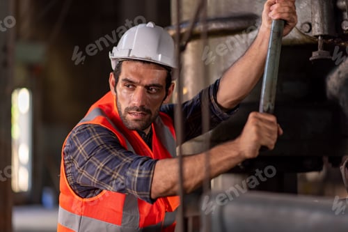 Preview: Worker at machine in factory, Metal industry worker at factory.